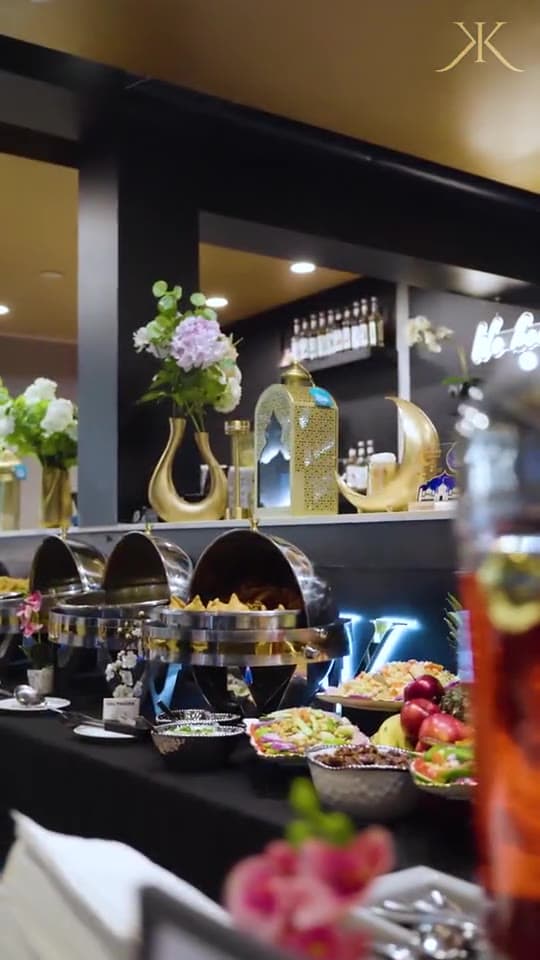 Catering chafing-dish buffet spread with fresh flowers, fruit platters and Ramadan-style decor