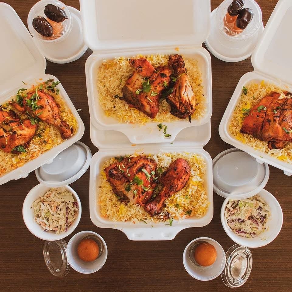 Boxed tandoori chicken and rice meals with dates, prepared for Ramadan meal distribution