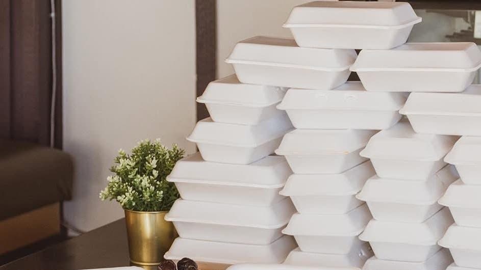 A large stack of packaged to-go meal containers prepared for a weekly food drive