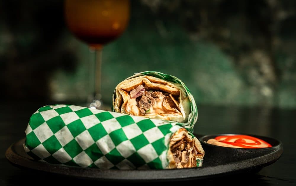 Kabab wrap sliced in half, showing the grilled kabab filling